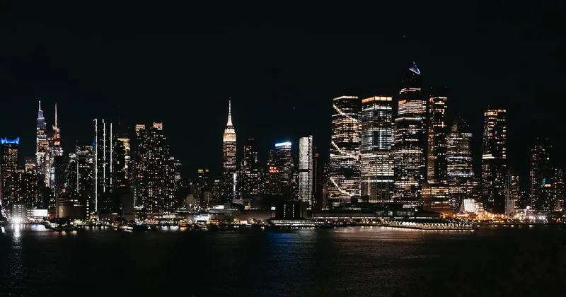 Small group on a night minibus NYC bus tour looking at the lit Manhattan skyline from the New Jersey waterfront