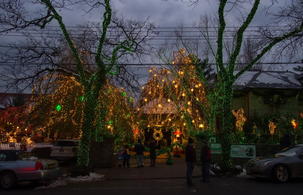 Christmas lights covering the trees and front yard of a house in Dyker Heights, Brooklyn, the stop on NYC holiday lights bus tours